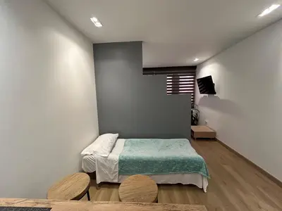 a bedroom with a bed and two wooden chairs at Elegante lugar a pasos del metro in Medellín