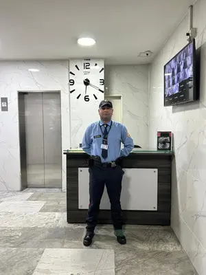 a man standing in front of a counter with a clock at Elegante lugar a pasos del metro in Medellín