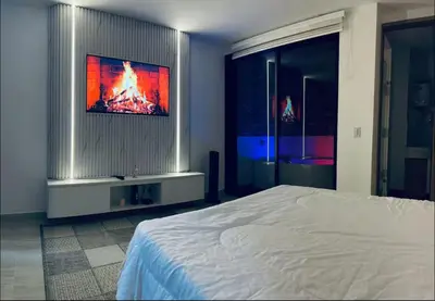 a bedroom with a bed and a tv on a wall at Aparta- estudio de lujo con jacuzzi in Medellín
