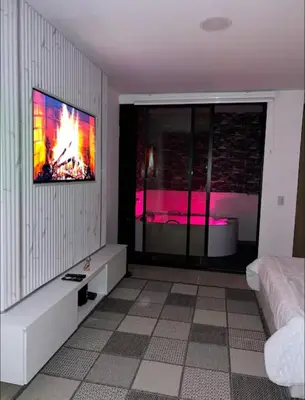 a bedroom with a tv hanging on a wall at Aparta- estudio de lujo con jacuzzi in Medellín
