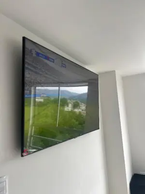 a flat screen tv hanging on a wall with a window at Central, Universidades y Centro Comercial in Manizales