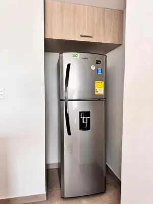 a stainless steel refrigerator in a kitchen with a counter at Central, Universidades y Centro Comercial in Manizales