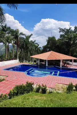 a large swimming pool with a pavilion and palm trees at Casa de campo El Jaguar in San Jerónimo