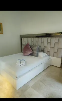 a large white bed with two shoes on it at Casa de campo El Jaguar in San Jerónimo
