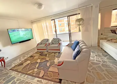 a living room with two couches and a flat screen tv at Apartamento Stay Medellín Laureles in Medellín