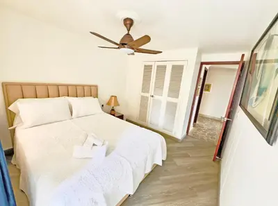 a bedroom with a white bed and a ceiling fan at Apartamento Stay Medellín Laureles in Medellín