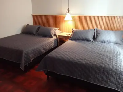 a hotel room with two beds and a lamp at Casa Frailejón Manizales in Manizales