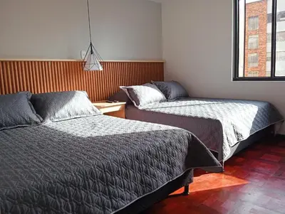 a bedroom with two beds and a window at Casa Frailejón Manizales in Manizales