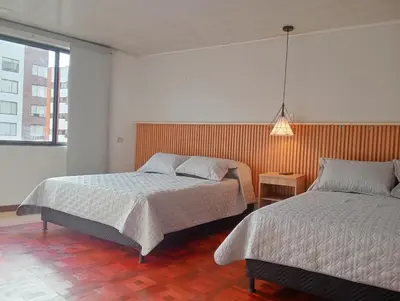 a bedroom with two beds and a pendant light at Casa Frailejón Manizales in Manizales