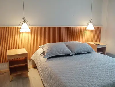 a bedroom with a bed with two lights above it at Casa Frailejón Manizales in Manizales