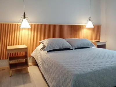 a bedroom with a large bed and two lights at Casa Frailejón Manizales in Manizales