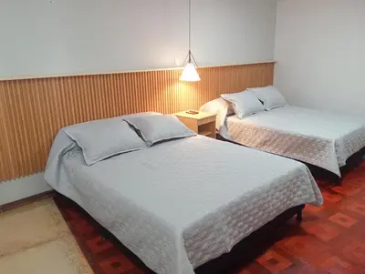 a room with two beds and a table with a lamp at Casa Frailejón Manizales in Manizales