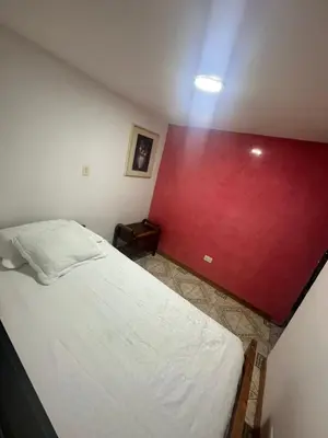 a bedroom with a bed with a red wall at Apartamento en Belén la palma medellin in Medellín