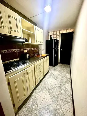 a kitchen with white cabinets and a black refrigerator at Apartamento en Belén la palma medellin in Medellín