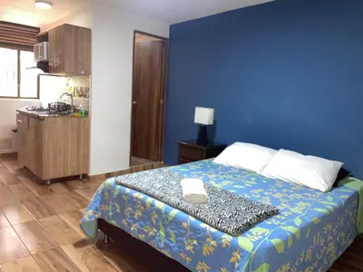 a bedroom with a bed with a blue wall at Loft Belén cerca a Unicentro y Unidad Deportiva Belén Sofá cama in Medellín