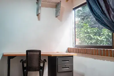 a desk with a chair next to a window at Loft Belén cerca a Unicentro y Unidad Deportiva Belén Sofá cama in Medellín