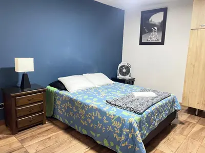 a blue bedroom with a bed and a night stand at Loft Belén cerca a Unicentro y Unidad Deportiva Belén Sofá cama in Medellín
