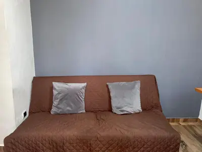 a brown couch with two pillows on top of it at Loft Belén cerca a Unicentro y Unidad Deportiva Belén Sofá cama in Medellín