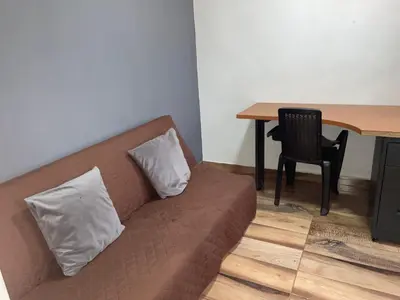 a couch with two pillows sitting next to a table at Loft Belén cerca a Unicentro y Unidad Deportiva Belén Sofá cama in Medellín