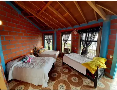 a bedroom with two beds and a brick wall at Bed and bath at Villacarolina in Titiribí