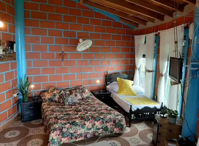 a bedroom with a bed next to a brick wall at Bed and bath at Villacarolina in Titiribí
