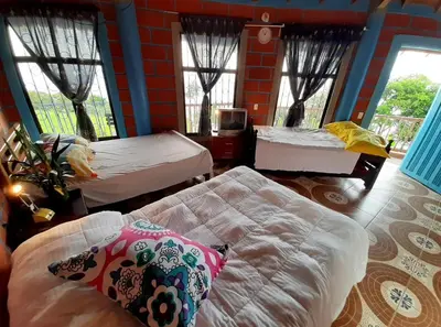 a room with two beds and a couch and windows at Bed and bath at Villacarolina in Titiribí
