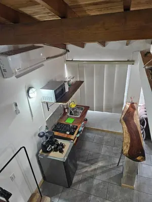 a room with a kitchen with a bed and a table at Cozy, Convenient and Affordable Loft In Laureles in Medellín