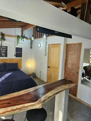 a bedroom with a bed with a wooden platform at Cozy, Convenient and Affordable Loft In Laureles in Medellín