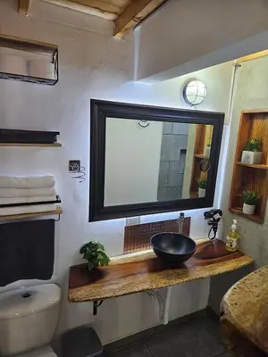 a bathroom with a sink and a mirror on a counter at Cozy, Convenient and Affordable Loft In Laureles in Medellín