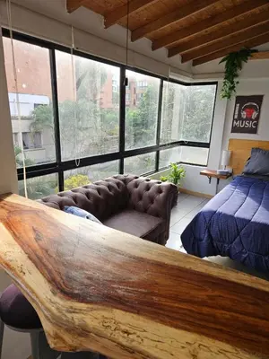 a bedroom with a couch and a bed and a large window at Cozy, Convenient and Affordable Loft In Laureles in Medellín