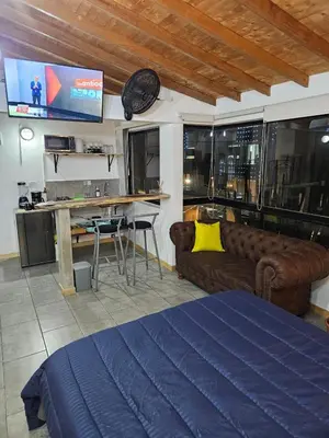 a room with a bed and a couch and a table at Cozy, Convenient and Affordable Loft In Laureles in Medellín