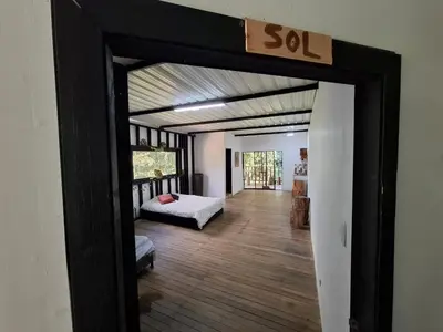 an open door to a bedroom with a bed and a sign at Cabaña sol wifi jacuzzi charcos parking in Barbosa