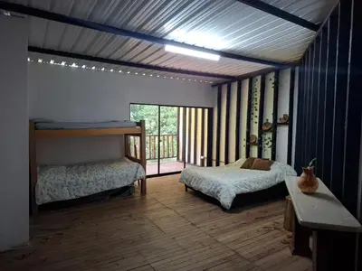 a bedroom with two beds and a large window at Cabaña sol wifi jacuzzi charcos parking in Barbosa
