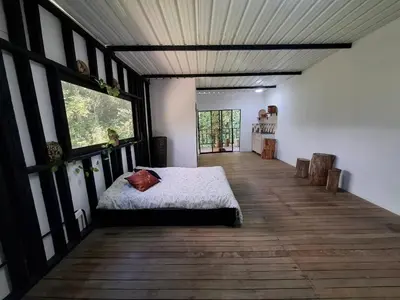 a bedroom with a bed on a wooden floor at Cabaña sol wifi jacuzzi charcos parking in Barbosa