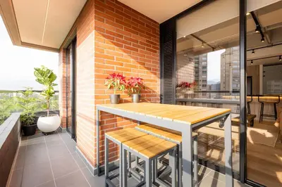 a dining room with a brick wall and a table and benches at Central, Modern Apartment in Envigado in Envigado