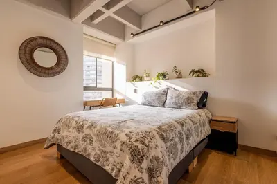 a bedroom with a large bed and a mirror at Central, Modern Apartment in Envigado in Envigado