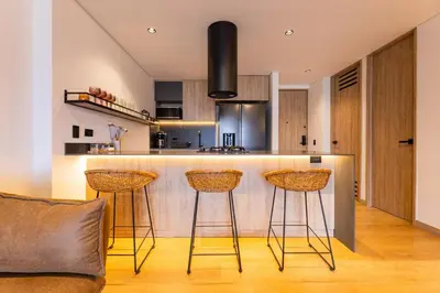 a kitchen with two bar stools and a counter at Spacious 2H Modern in Envigado in Envigado