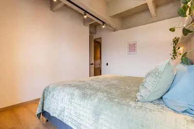 a bedroom with a bed with blue pillows at Spacious 2H Modern in Envigado in Envigado