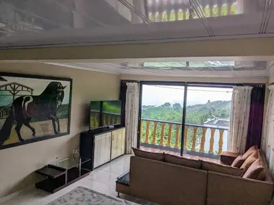 a living room with a couch and a large window at El descanso perfecto in Palestina