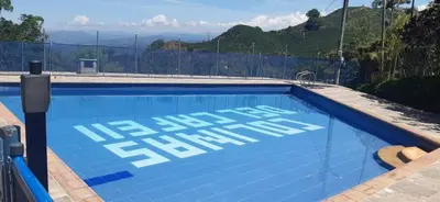 a blue swimming pool with the words emergency exit at El descanso perfecto in Palestina
