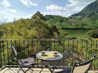 a table and two chairs on a balcony with mountains at Jardín Utopía in Jardin