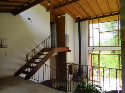 a staircase in a house with a large window at Jardín Utopía in Jardin