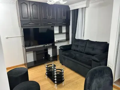 a living room with a black couch and a flat screen tv at Luxurious Stay 2 in Bello