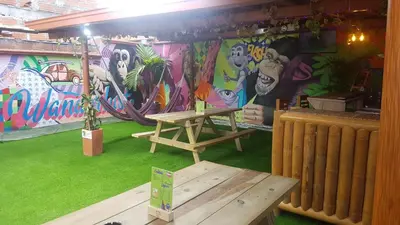 a room with a table and a wall with graffiti at Purple Monkey Hostel in Medellín