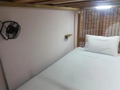 a white bed in a room with a window at Purple Monkey Hostel in Medellín