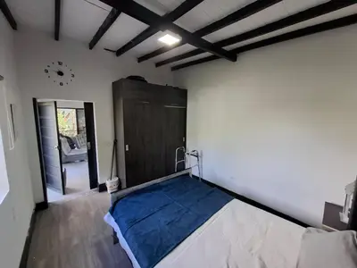 a room with a bed and a wooden door at Casa de lujo wifi jacuzzi charcos parking in Barbosa