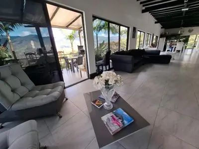 a living room with a vase of flowers on a table at Casa de lujo wifi jacuzzi charcos parking in Barbosa