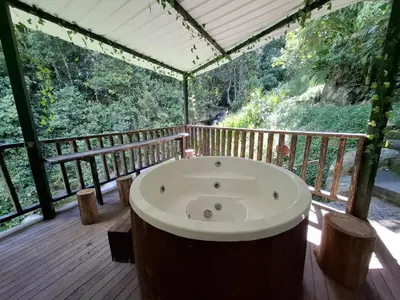a jacuzzi tub on a wooden deck at Casa de lujo wifi jacuzzi charcos parking in Barbosa