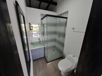 a bathroom with a toilet and a glass shower at Casa de lujo wifi jacuzzi charcos parking in Barbosa
