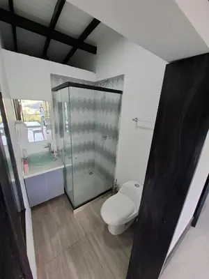 a bathroom with a toilet and a glass shower at Casa de lujo wifi jacuzzi charcos parking in Barbosa
